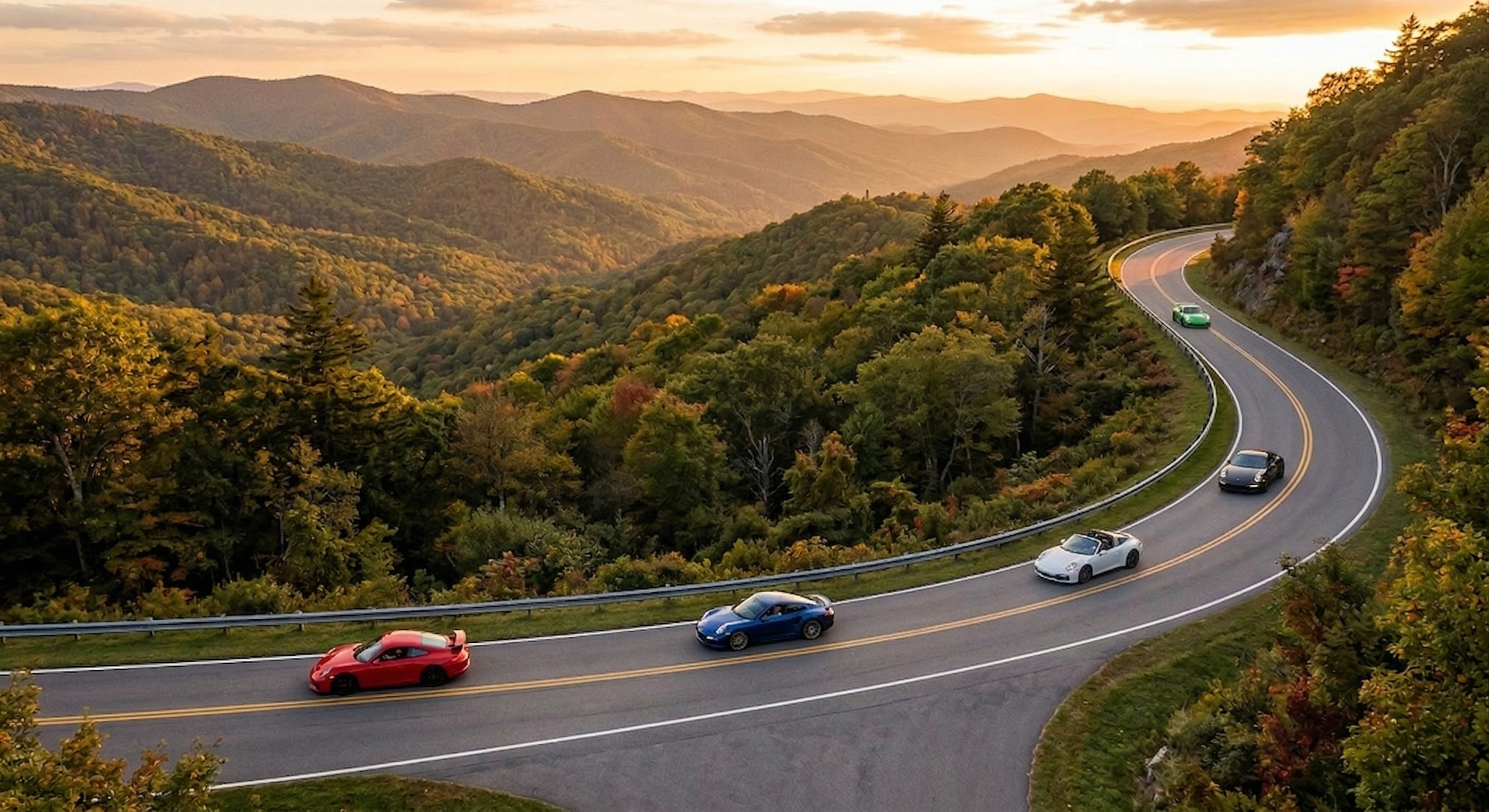 A sports car carving through a forested mountain road at golden hour
